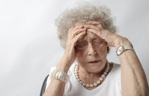 Femme senior se tenant la tête, symptôme de stress lié aux acouphènes chez l'adulte