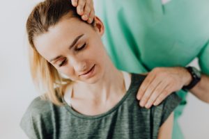 Kinésithérapeute manipulant les cervicales d'une patiente pour soulager un acouphène cervicale