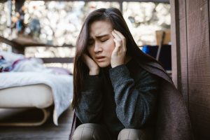 Femme se tenant la tête, symptôme de vertige et d'acouphène