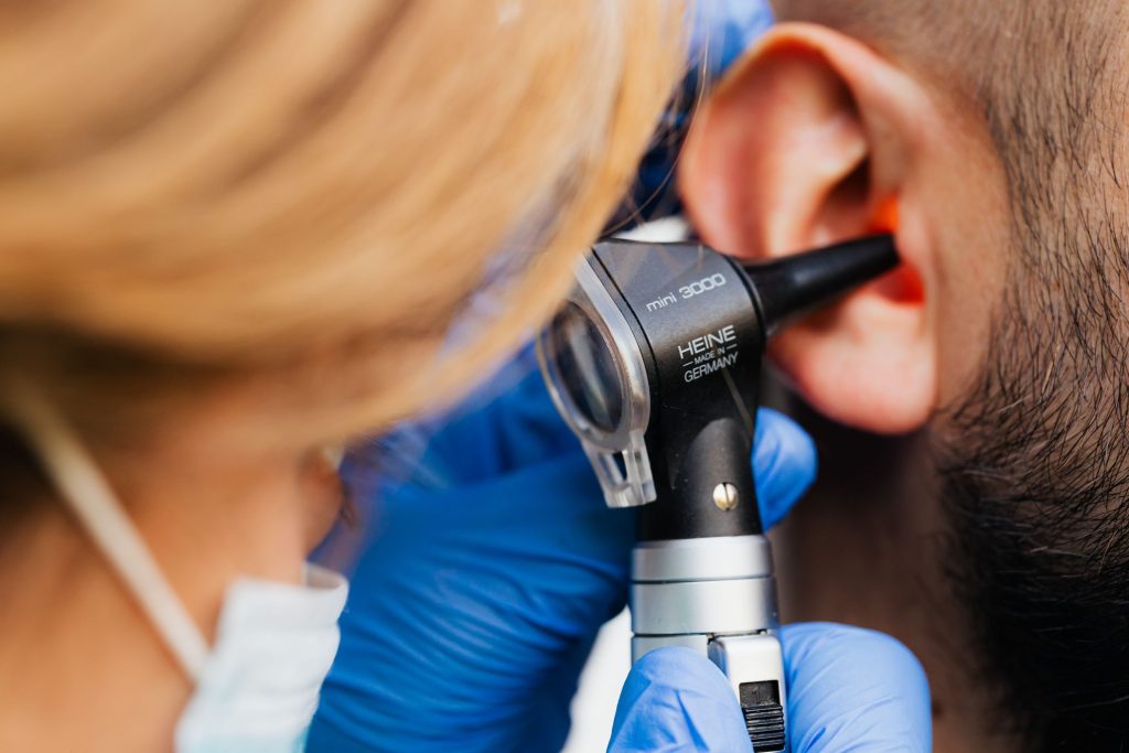 Audioprothésiste réalisant un examen otoscopique de l'oreille d'un patient