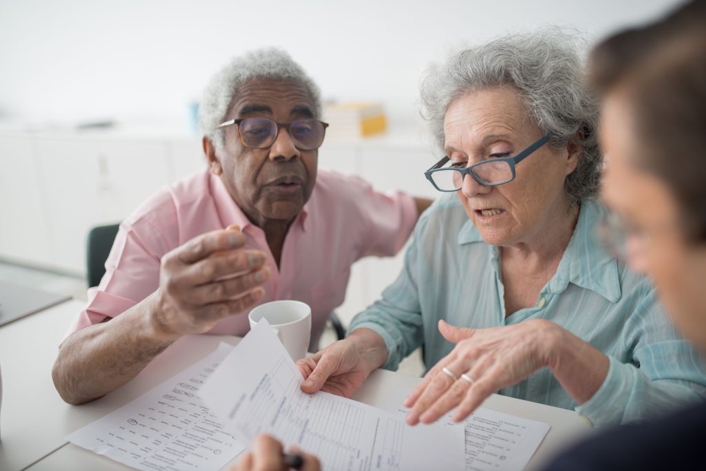 Couple senior consultant un dossier de remboursement pour aides auditives